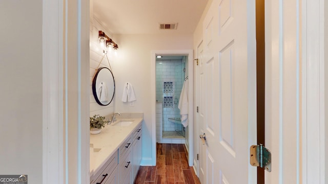 1346 Wind Chime Ct, Lawrenceville, GA 30045 - bathroom with double vanity, tiled shower, and wood finished floors