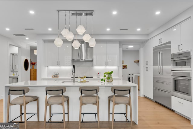 2425 Peachtree Rd NE Unit 902, Atlanta, GA 30305 - kitchen with modern cabinets, wall chimney range hood, high end refrigerator, independent washer and dryer, and light countertops