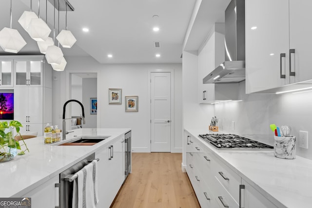 2425 Peachtree Rd NE Unit 902, Atlanta, GA 30305 - kitchen featuring wall chimney exhaust hood, appliances with stainless steel finishes, light wood-type flooring, beverage cooler, and white cabinetry