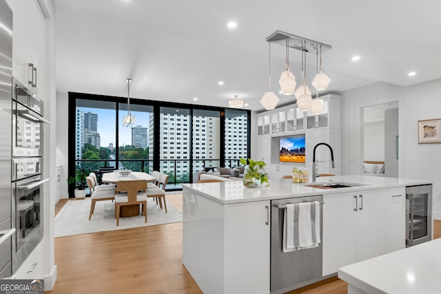 2425 Peachtree Rd NE Unit 902, Atlanta, GA 30305 - kitchen with stainless steel dishwasher, beverage cooler, light countertops, light wood-style flooring, and recessed lighting