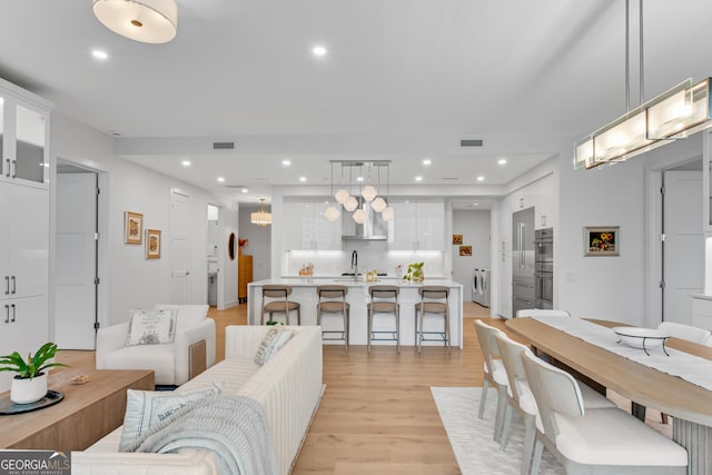 2425 Peachtree Rd NE Unit 902, Atlanta, GA 30305 - living room with light wood-type flooring, independent washer and dryer, and recessed lighting