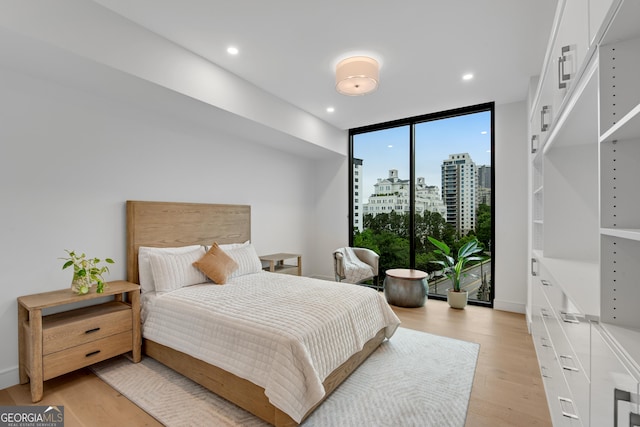 2425 Peachtree Rd NE Unit 902, Atlanta, GA 30305 - bedroom with light wood-style flooring, floor to ceiling windows, recessed lighting, and a city view