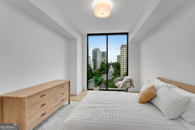 2425 Peachtree Rd NE Unit 902, Atlanta, GA 30305 - bedroom with floor to ceiling windows, light wood-type flooring, and a city view