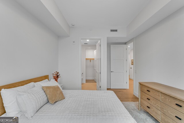 2425 Peachtree Rd NE Unit 902, Atlanta, GA 30305 - bedroom featuring light wood-style flooring and a walk in closet