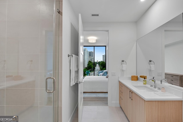 2425 Peachtree Rd NE Unit 902, Atlanta, GA 30305 - bathroom with vanity, connected bathroom, a shower stall, and tile patterned flooring