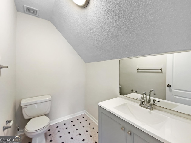 1792 Portwest Way, Hampton, GA 30228 - bathroom featuring vaulted ceiling, vanity, tile patterned floors, and a textured ceiling