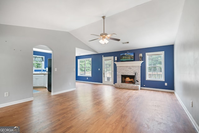 135 Pinewood Cir, Colbert, GA 30628 - unfurnished living room with a ceiling fan, plenty of natural light, wood finished floors, a lit fireplace, and lofted ceiling
