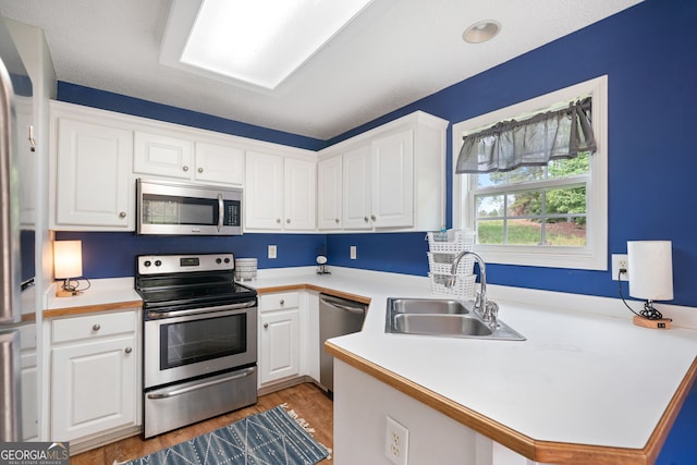 135 Pinewood Cir, Colbert, GA 30628 - kitchen with stainless steel appliances, white cabinetry, a peninsula, and light countertops