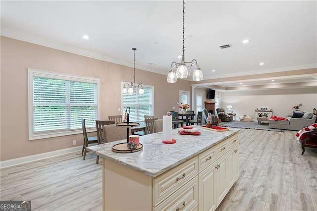 7131 Ridge Rd, Hiram, GA 30141 - kitchen with a chandelier, light wood-type flooring, ornamental molding, a center island, and light stone counters