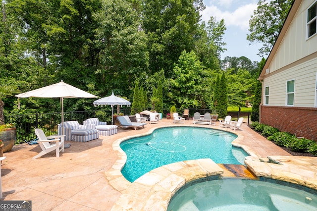 7131 Ridge Rd, Hiram, GA 30141 - view of swimming pool with a patio area, view of wooded area, and a pool with connected hot tub