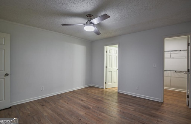5640 Redan Cir, Stone Mountain, GA 30088 - unfurnished bedroom with a textured ceiling, wood finished floors, baseboards, a walk in closet, and a ceiling fan
