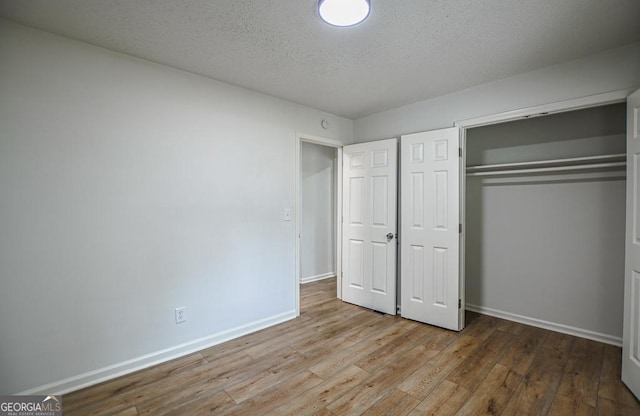 5640 Redan Cir, Stone Mountain, GA 30088 - unfurnished bedroom featuring wood finished floors, baseboards, a closet, and a textured ceiling