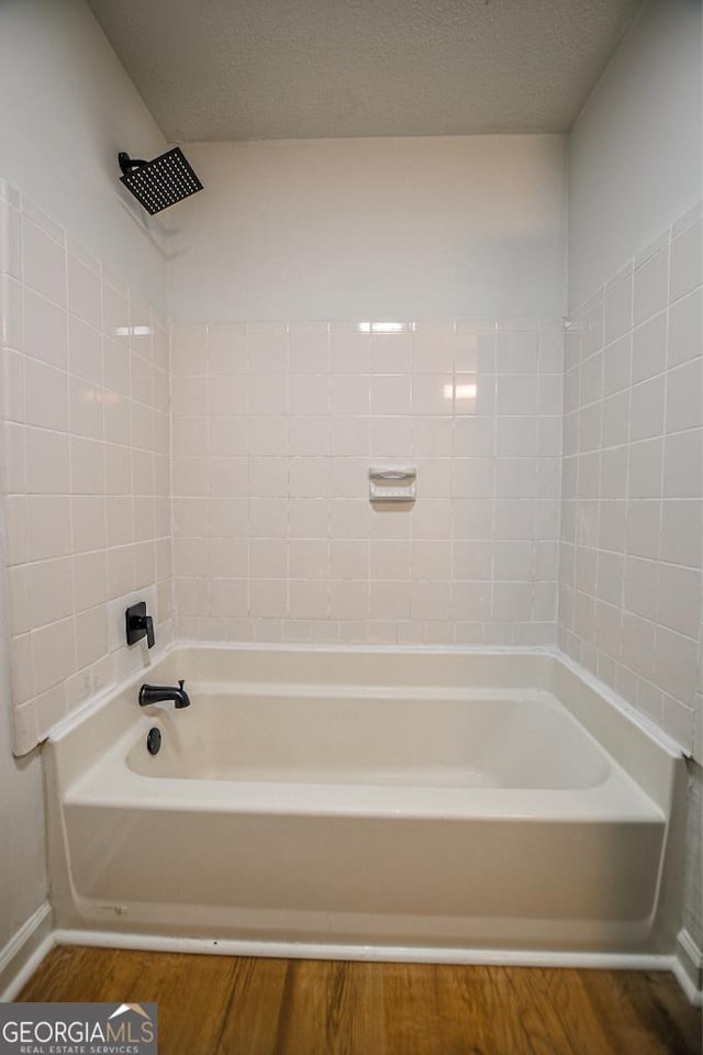 5640 Redan Cir, Stone Mountain, GA 30088 - bathroom featuring wood finished floors, bathing tub / shower combination, and baseboards