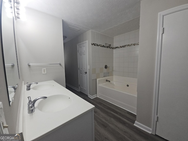 686 Favorwood Dr SW, Marietta, GA 30060 - bathroom with a textured ceiling, wood finished floors, double vanity, shower / washtub combination, and baseboards