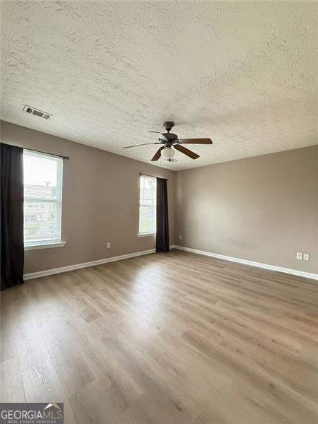 6634 Splashwater Dr, Flowery Branch, GA 30542 - unfurnished room with a textured ceiling, light wood-style flooring, and a ceiling fan