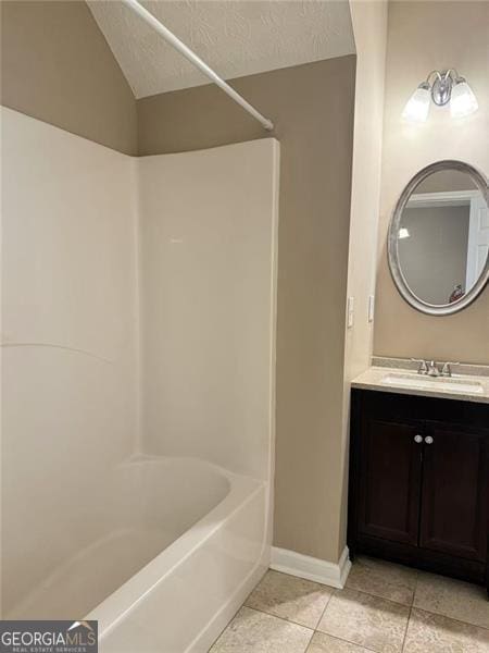 6634 Splashwater Dr, Flowery Branch, GA 30542 - bathroom featuring tile patterned flooring, vanity, washtub / shower combination, vaulted ceiling, and a textured ceiling