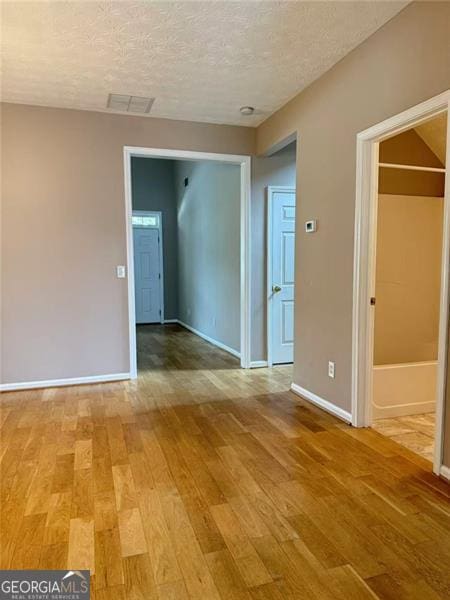 6634 Splashwater Dr, Flowery Branch, GA 30542 - spare room with light wood-style flooring and a textured ceiling