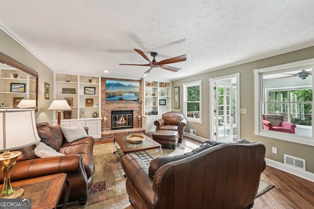 10875 Shagbark Trl, Roswell, GA 30075 - living room with a ceiling fan, wood finished floors, ornamental molding, a fireplace, and a textured ceiling
