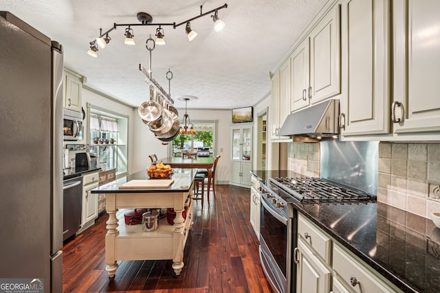 10875 Shagbark Trl, Roswell, GA 30075 - kitchen featuring appliances with stainless steel finishes, under cabinet range hood, dark wood-style flooring, decorative backsplash, and a textured ceiling