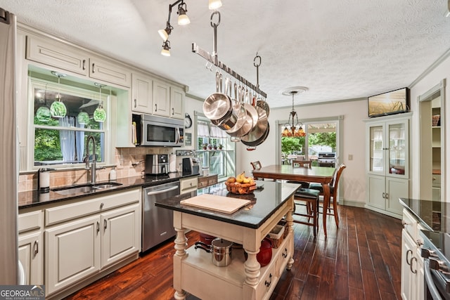 10875 Shagbark Trl, Roswell, GA 30075 - kitchen with appliances with stainless steel finishes, dark wood-type flooring, decorative backsplash, a textured ceiling, and pendant lighting