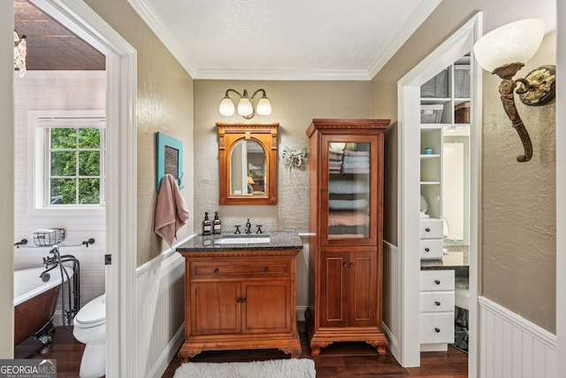 10875 Shagbark Trl, Roswell, GA 30075 - bathroom featuring wood finished floors, crown molding, a freestanding bath, a textured wall, and vanity
