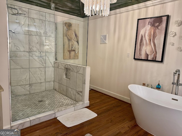 124 N Valhalla Ln, Cordele, GA 31015 - bathroom featuring a stall shower, a freestanding bath, a chandelier, wood finished floors, and baseboards