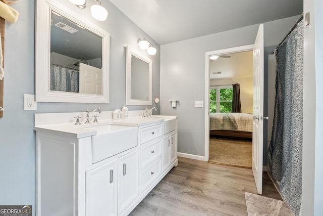 5102 Yellow Stone Dr, Flowery Branch, GA 30542 - bathroom featuring double vanity, connected bathroom, wood finished floors, baseboards, and a shower with shower curtain