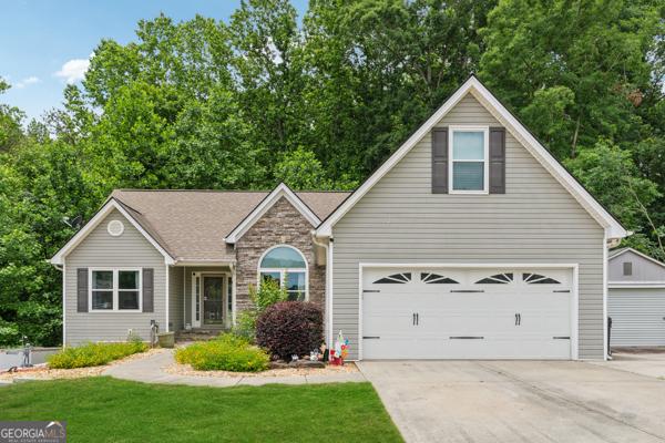 5102 Yellow Stone Dr, Flowery Branch, GA 30542 - view of front of property with driveway, a garage, stone siding, and a front yard