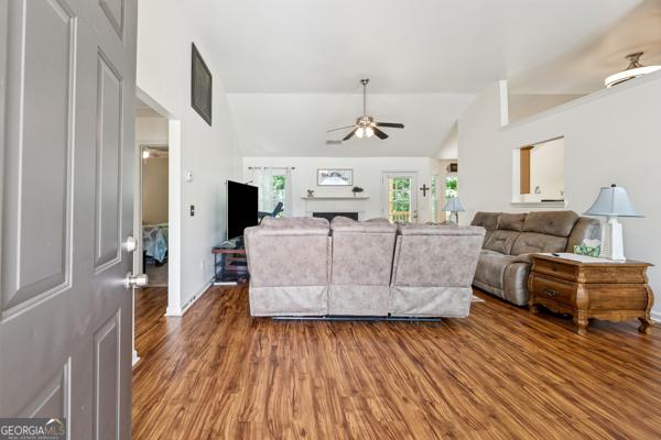 5102 Yellow Stone Dr, Flowery Branch, GA 30542 - living area featuring lofted ceiling, ceiling fan, and wood finished floors