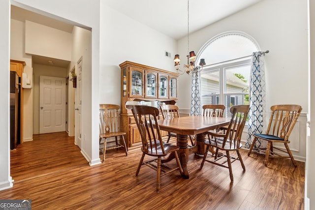 5102 Yellow Stone Dr, Flowery Branch, GA 30542 - dining space featuring a towering ceiling, wood finished floors, a chandelier, and baseboards