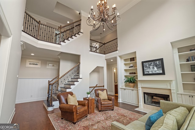 4530 Westgate Dr, Cumming, GA 30040 - living area with wood finished floors, stairs, crown molding, built in shelves, and a towering ceiling