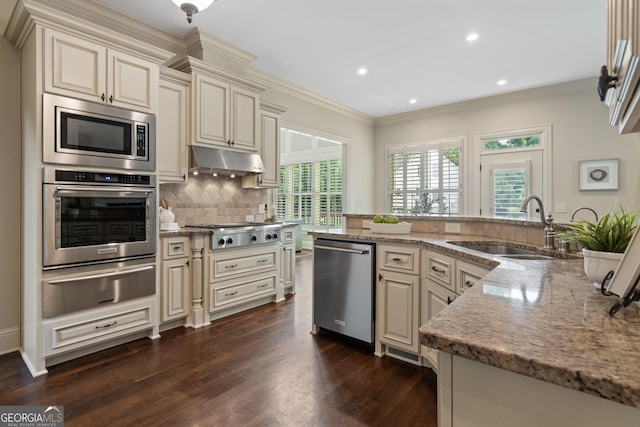 4530 Westgate Dr, Cumming, GA 30040 - kitchen with stainless steel appliances, cream cabinets, a warming drawer, crown molding, and recessed lighting