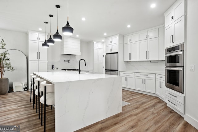 194 Branch Valley Way, Dallas, GA 30132 - kitchen featuring appliances with stainless steel finishes, recessed lighting, backsplash, light wood-style flooring, and premium range hood