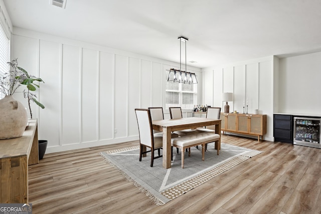 194 Branch Valley Way, Dallas, GA 30132 - dining space with a decorative wall, beverage cooler, light wood-style floors, and a chandelier