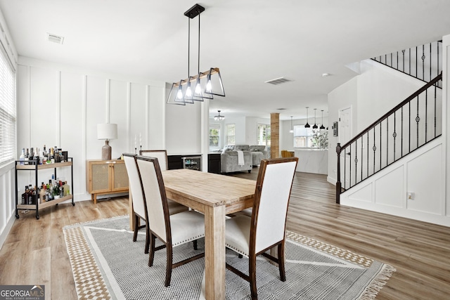 194 Branch Valley Way, Dallas, GA 30132 - dining area featuring light wood-type flooring, stairs, a chandelier, a decorative wall, and wine cooler
