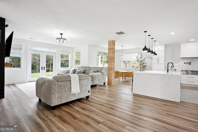 194 Branch Valley Way, Dallas, GA 30132 - living room with light wood finished floors, recessed lighting, a chandelier, french doors, and decorative columns