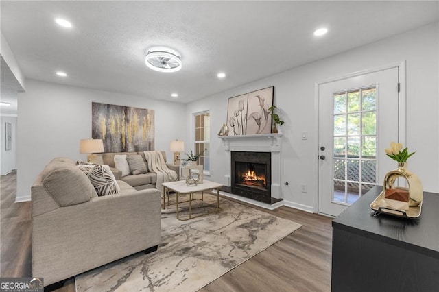 9404 Cypress Ln, Jonesboro, GA 30238 - living room with wood finished floors, recessed lighting, a lit fireplace, and baseboards
