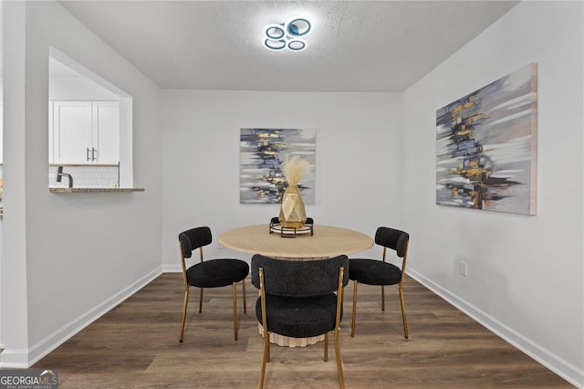 9404 Cypress Ln, Jonesboro, GA 30238 - dining area featuring dark wood-style flooring, baseboards, and a textured ceiling