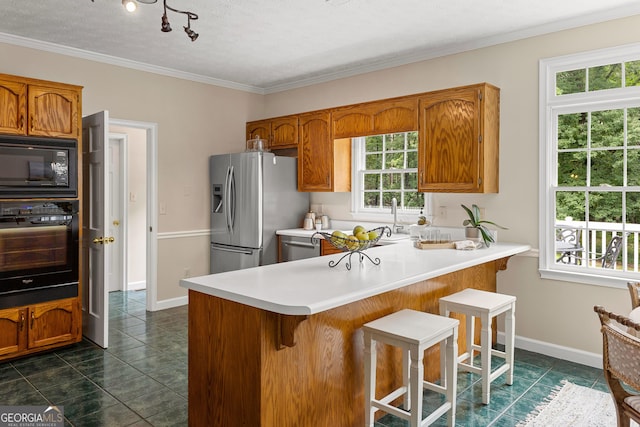 607 Lees Mill Rd, Fayetteville, GA 30214 - kitchen with black appliances, dark tile patterned flooring, brown cabinetry, ornamental molding, and a textured ceiling