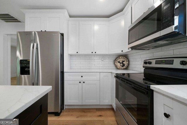 6 W Point Dr SE, Lindale, GA 30147 - kitchen featuring appliances with stainless steel finishes, tasteful backsplash, white cabinetry, and light stone counters