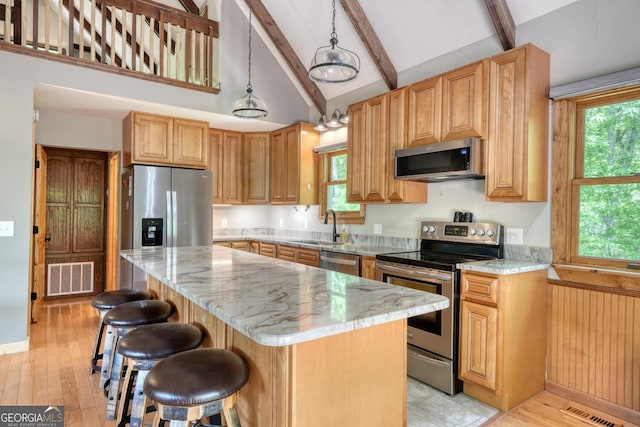 224 Shake Rag Rd, Hiawassee, GA 30546 - kitchen with appliances with stainless steel finishes, beamed ceiling, a sink, a kitchen island, and a kitchen breakfast bar