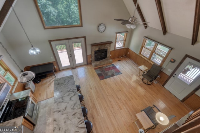 224 Shake Rag Rd, Hiawassee, GA 30546 - living room featuring a glass covered fireplace, high vaulted ceiling, a ceiling fan, beamed ceiling, and wood finished floors