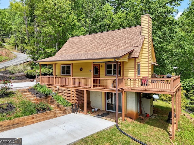 224 Shake Rag Rd, Hiawassee, GA 30546 - chalet / cabin with roof with shingles, a patio, a chimney, a wooden deck, and a front lawn