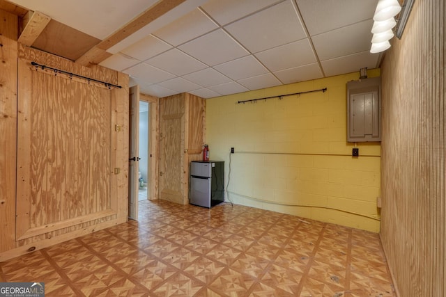 224 Shake Rag Rd, Hiawassee, GA 30546 - spare room with concrete block wall, electric panel, light flooring, and a drop ceiling