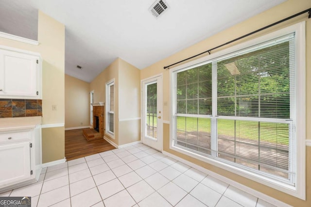 467 Ravinia Way, Lawrenceville, GA 30044 - unfurnished dining area with a fireplace with raised hearth, vaulted ceiling, baseboards, plenty of natural light, and light tile patterned floors