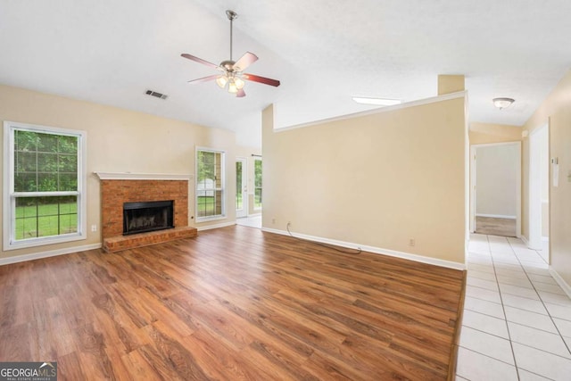 467 Ravinia Way, Lawrenceville, GA 30044 - unfurnished living room with a ceiling fan, vaulted ceiling, light wood-style flooring, baseboards, and a brick fireplace