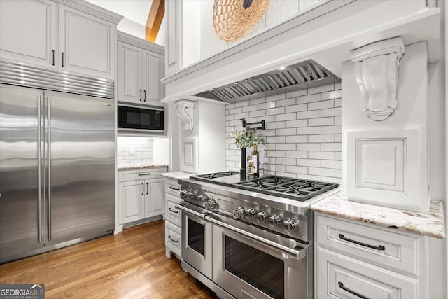 3057 Watsons Bnd, Milton, GA 30004 - kitchen with built in appliances, decorative backsplash, light stone countertops, white cabinets, and light wood finished floors