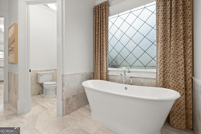 3057 Watsons Bnd, Milton, GA 30004 - bathroom with wainscoting, tile walls, a freestanding tub, and ornamental molding