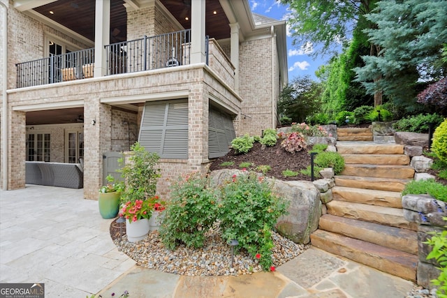 3057 Watsons Bnd, Milton, GA 30004 - view of home's exterior with brick siding, a patio area, a balcony, and stairs