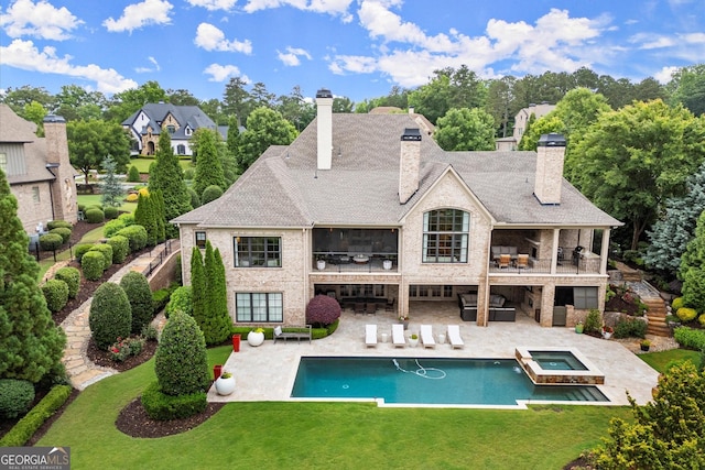 3057 Watsons Bnd, Milton, GA 30004 - back of house featuring a chimney, a patio area, a yard, and a pool with connected hot tub